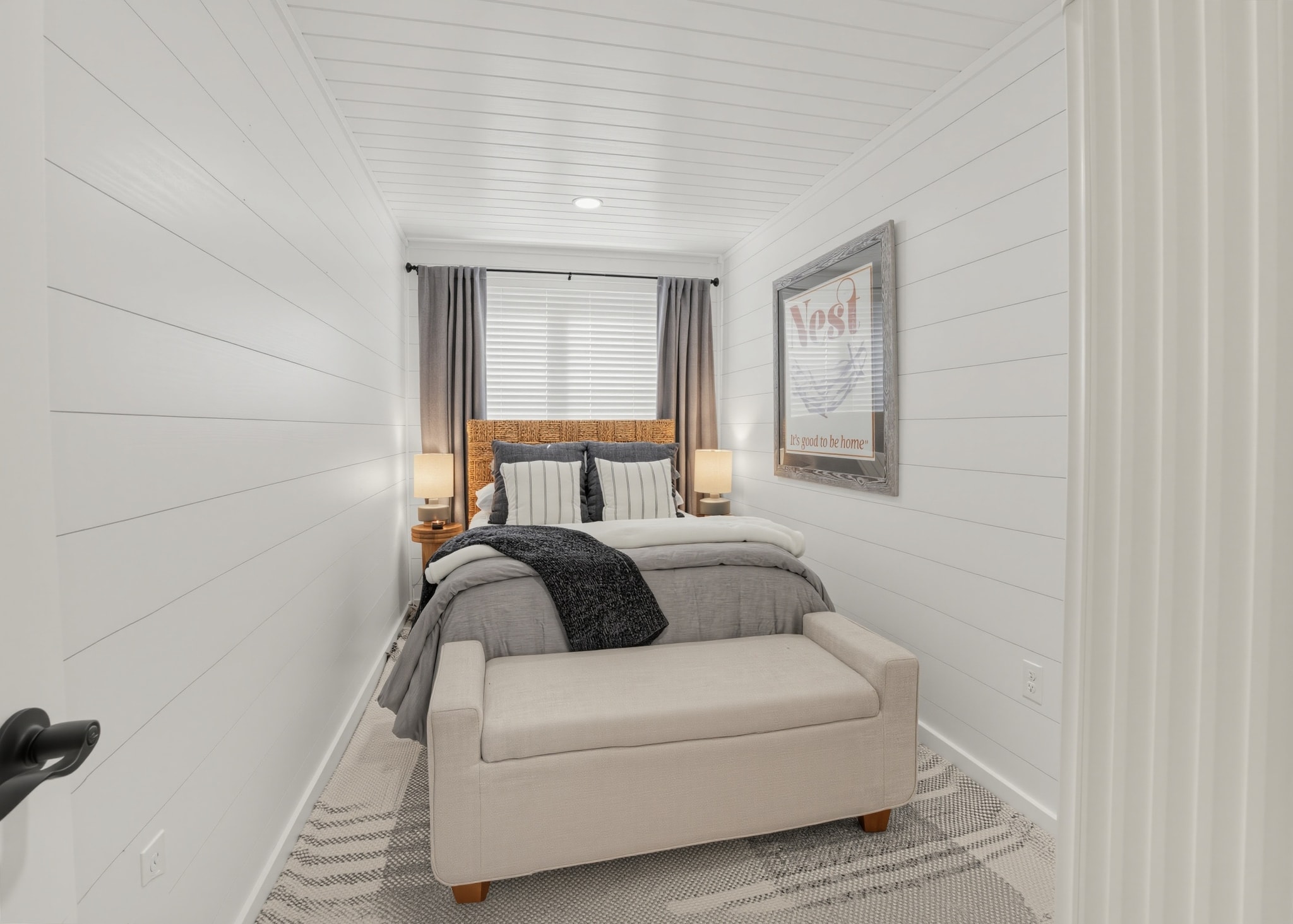 Guest bedroom with shiplap walls and cozy bench