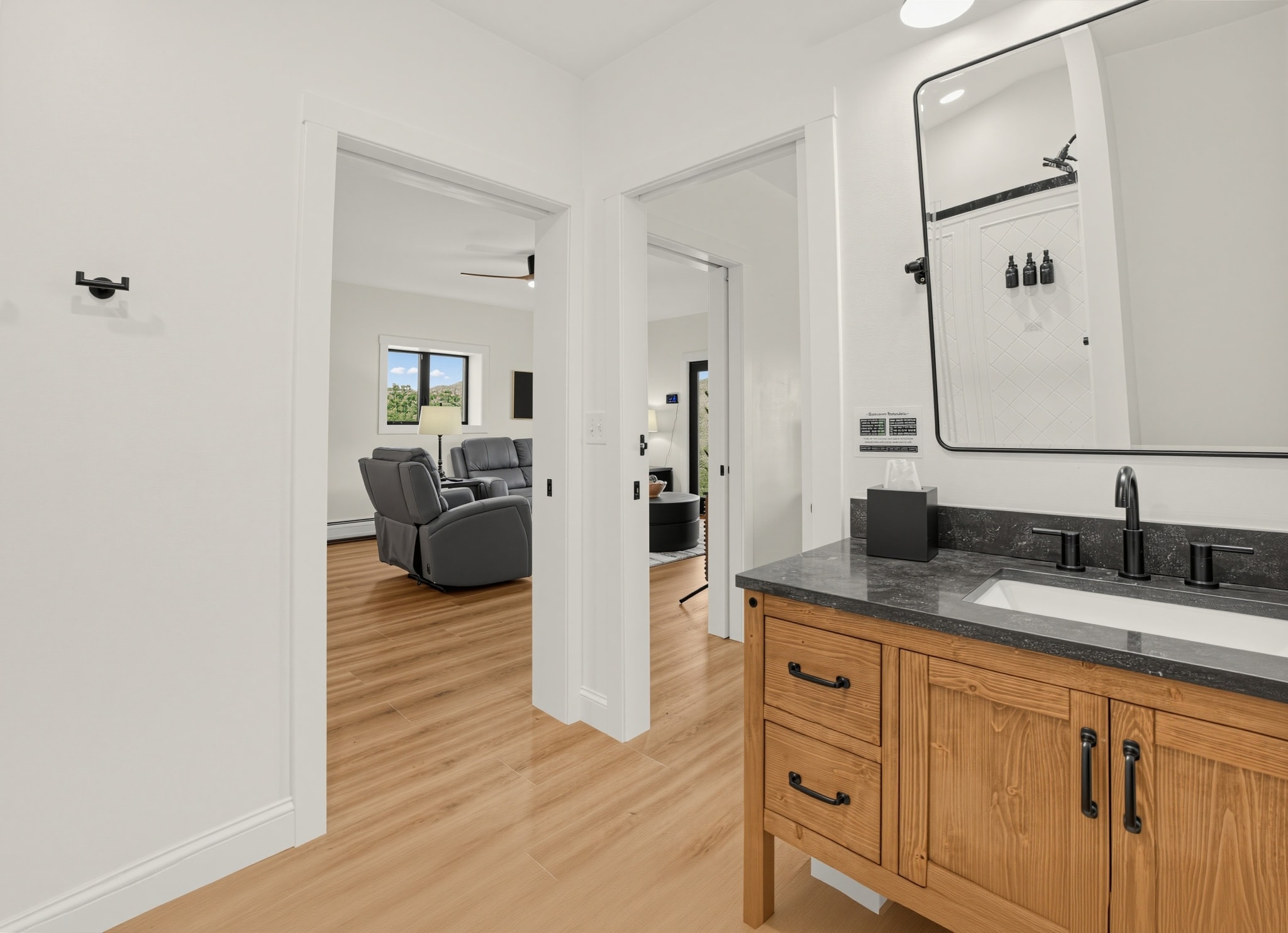 Guest bathroom with wood vanity and open hallway