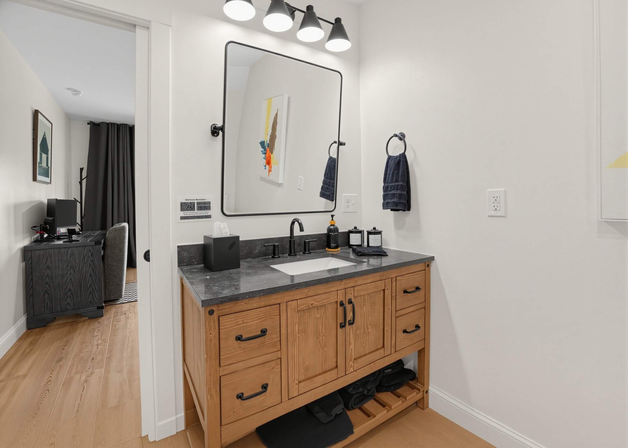 Guest bathroom wood vanity with black countertop