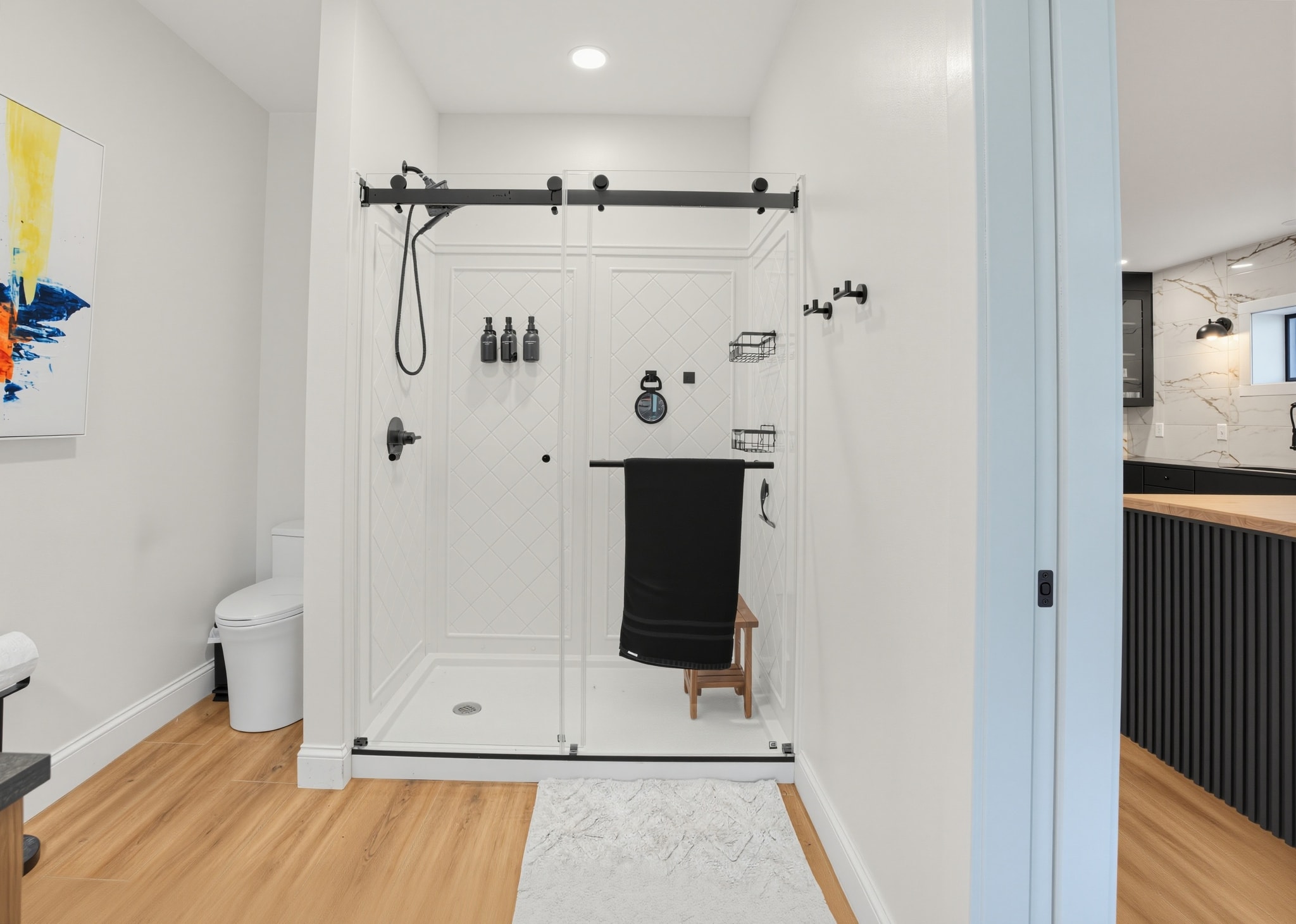Guest bathroom with glass shower enclosure and bench