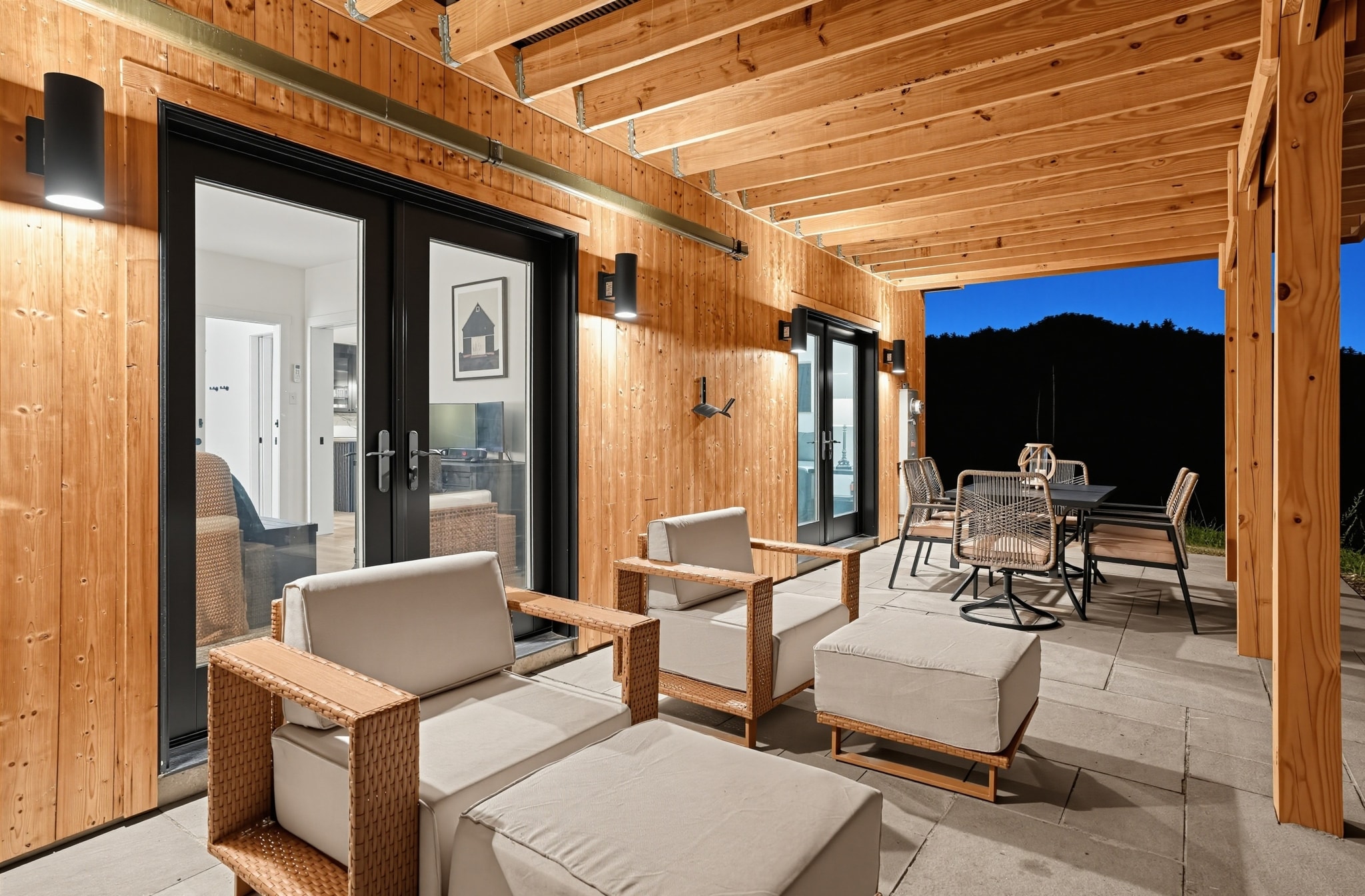 Covered deck with wicker lounge seating at dusk