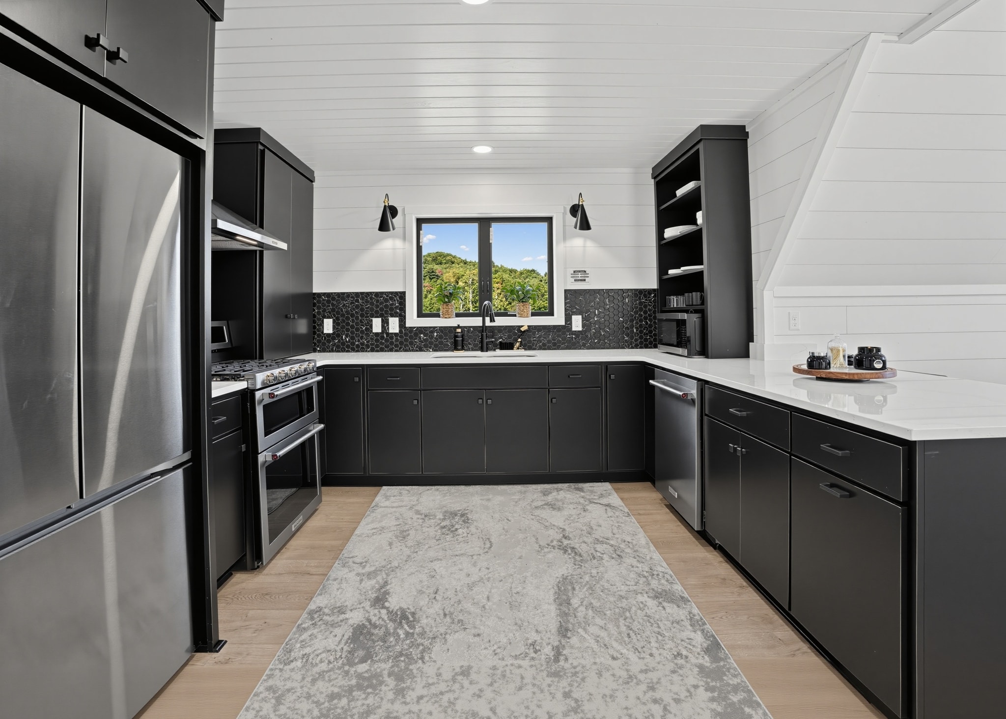Chef's kitchen with dark cabinets and stainless appliances