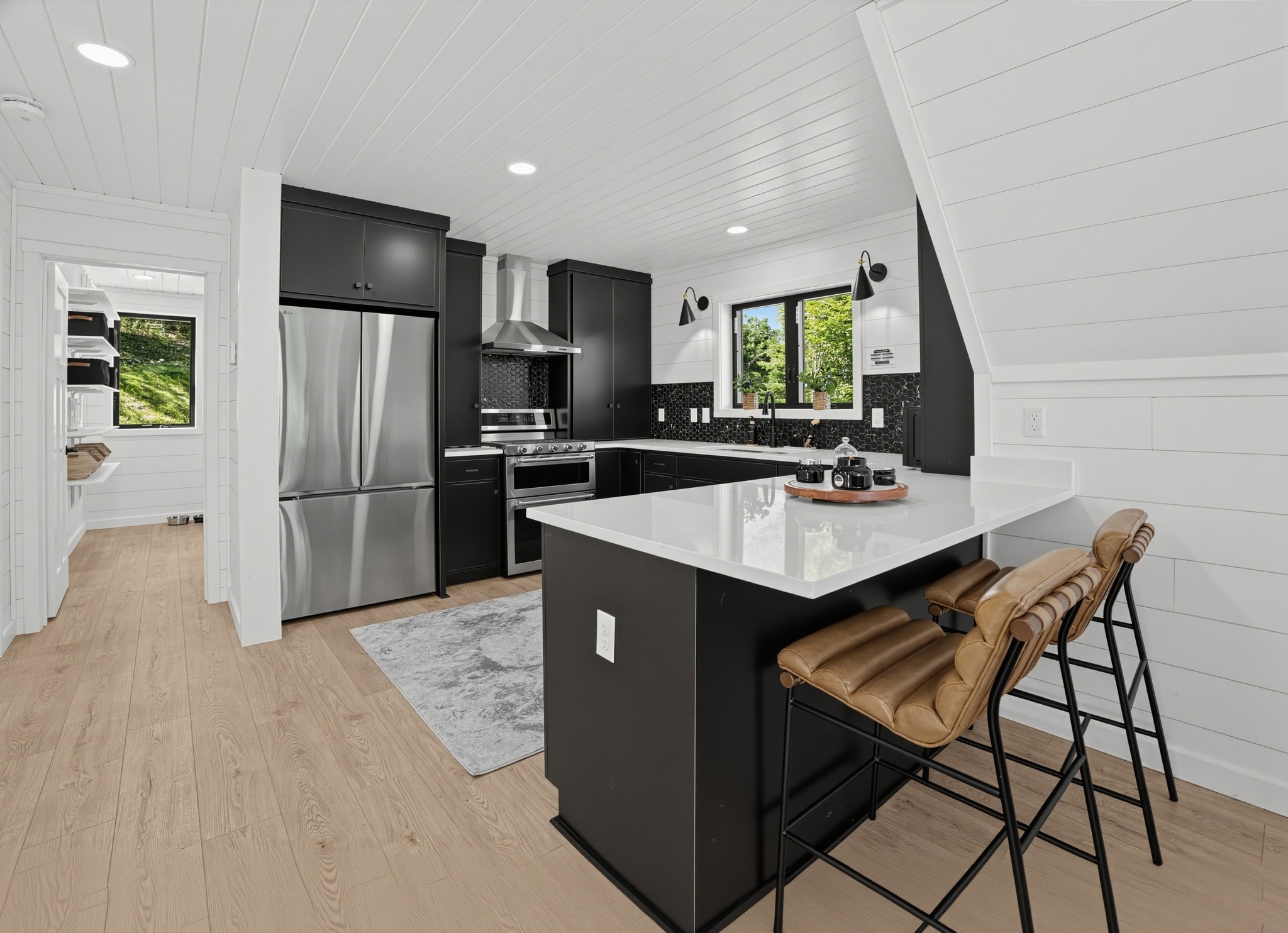 Kitchen with black island and leather bar stools