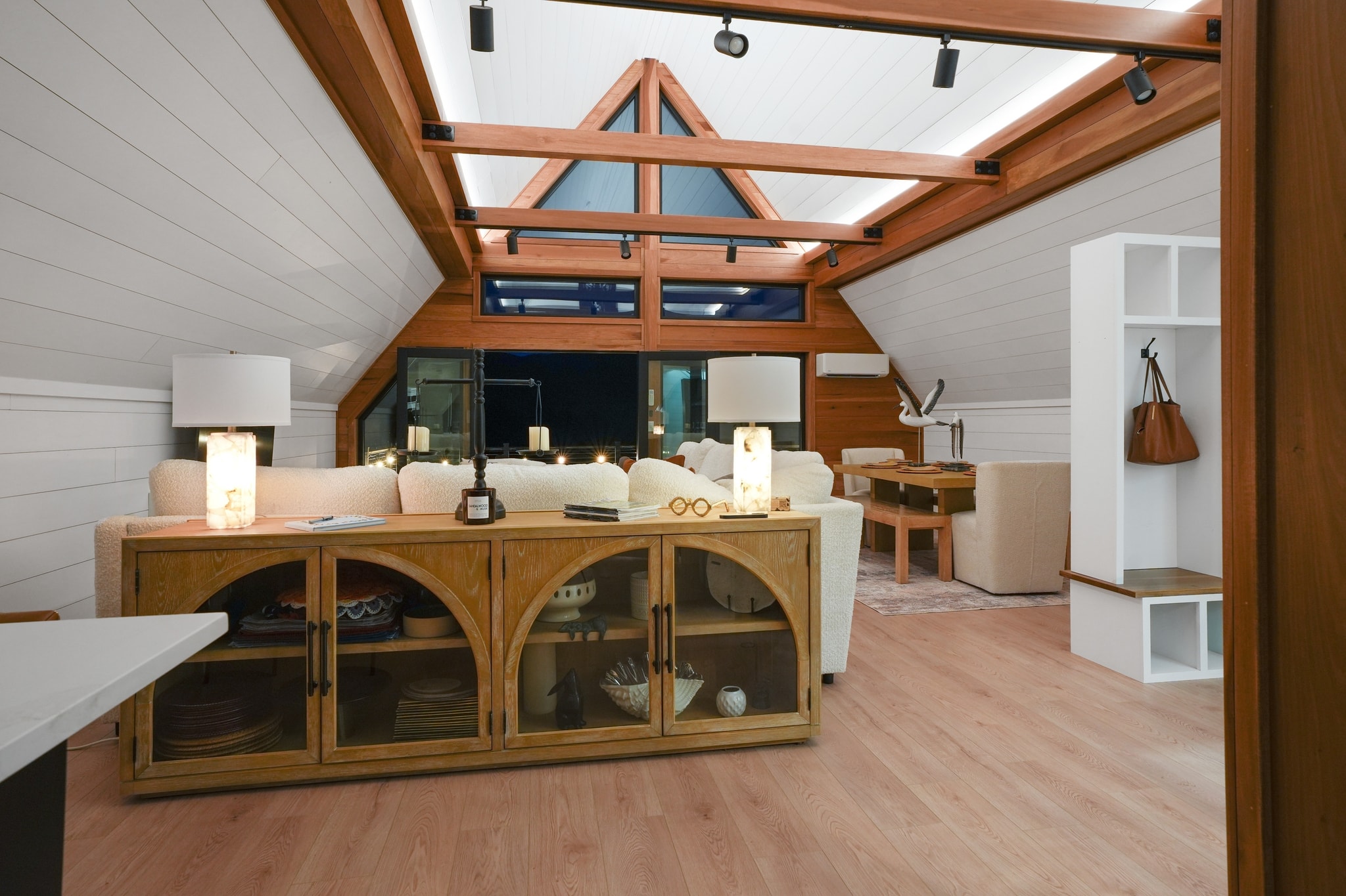 A-frame living room with wood credenza and night views