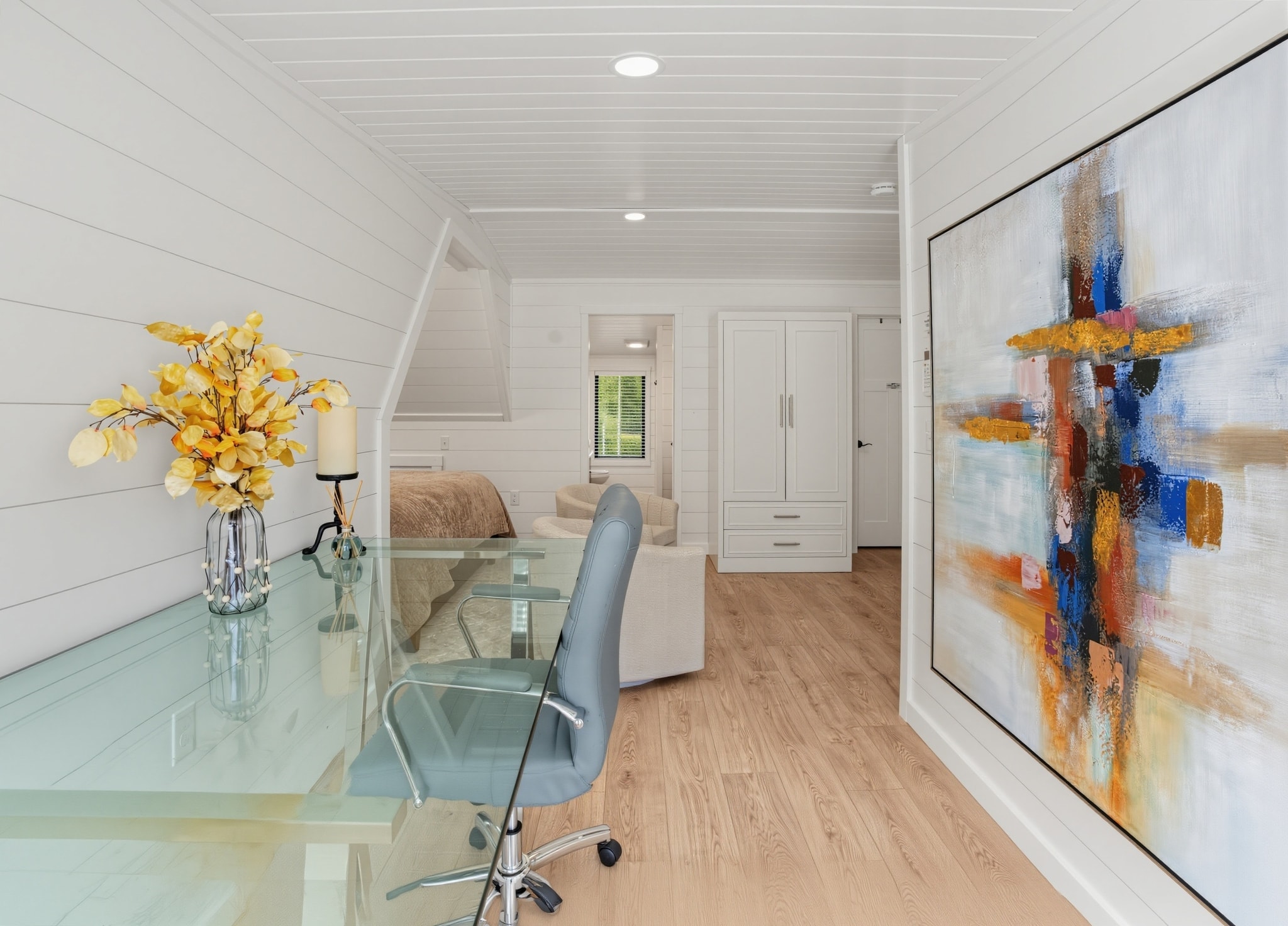 Owner's suite glass desk workspace with abstract art