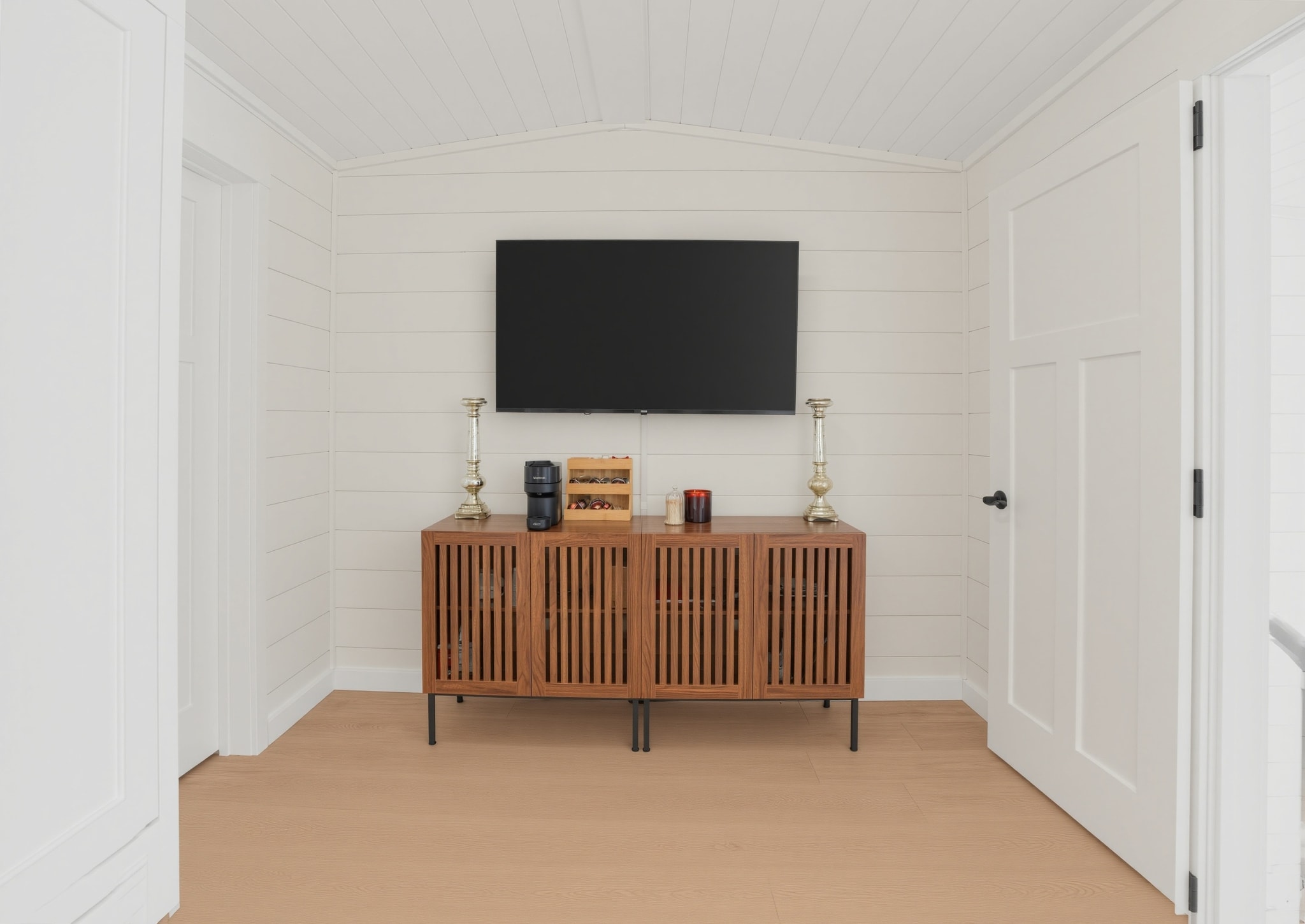 Owner's suite media room with TV and walnut credenza