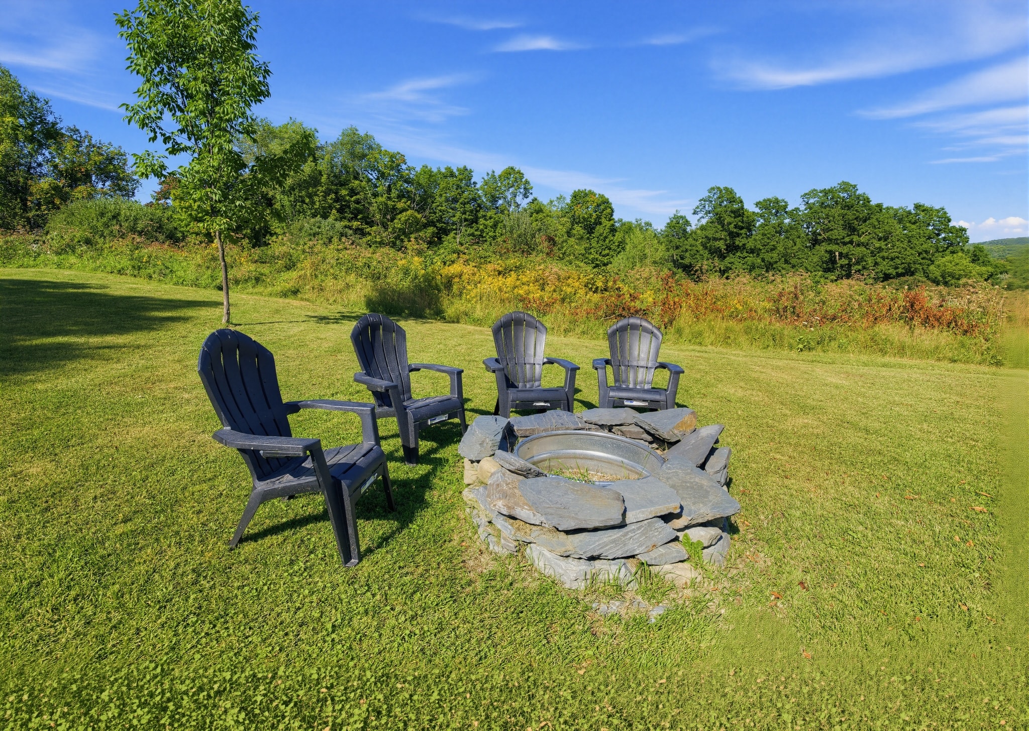 Stone fire pit with Adirondack chairs close up