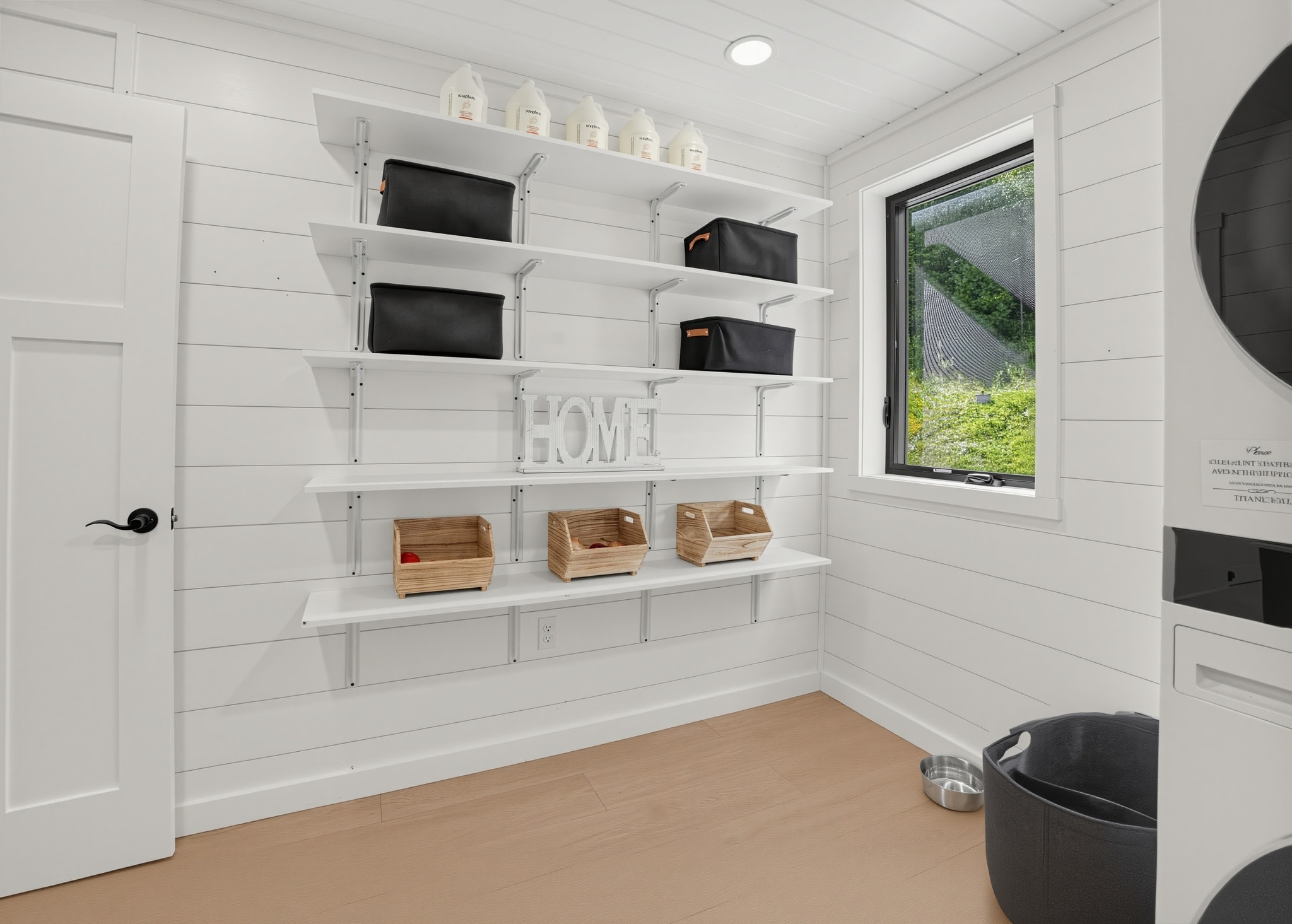 Laundry room with white shelving